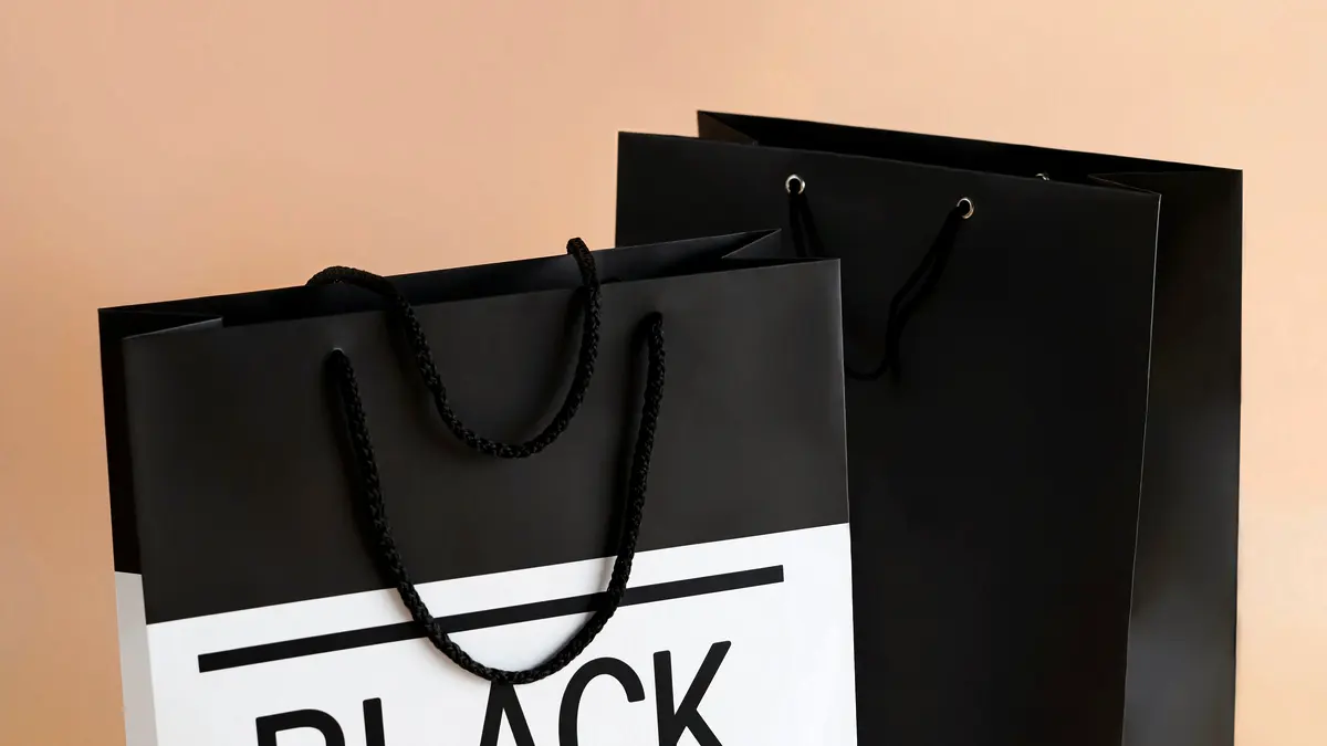 Paper shopping bags marked with Black Friday sale text.