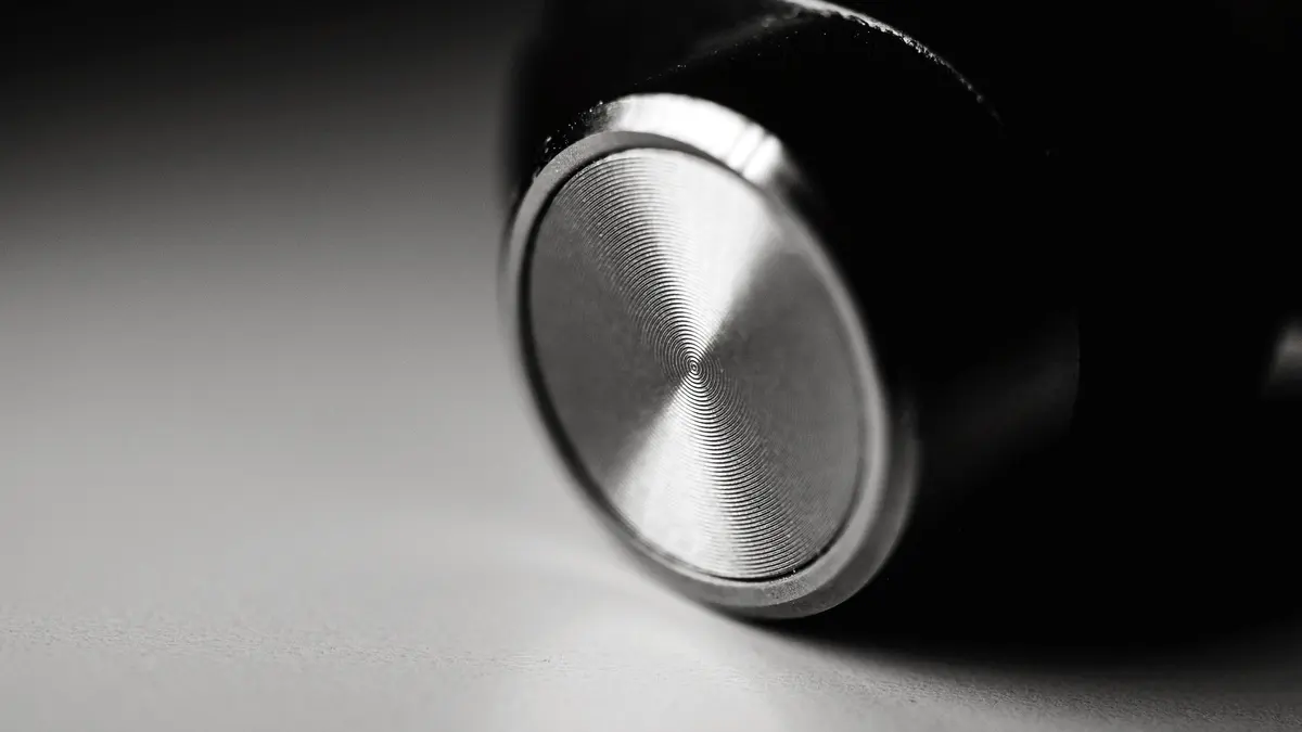 Macro photograph of a single wireless earbud.
