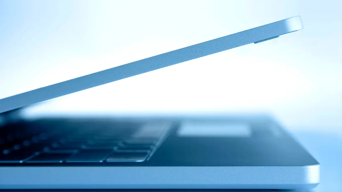 A slim laptop photographed side-on against a plain background.