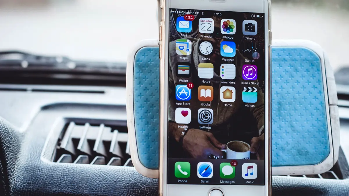 A phone mounted on a car dashboard in bright sunlight.